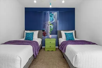 a bedroom with two beds and a blue wall at 3 Bedrooms 2 Bathrooms Lake Berkley home in Kissimmee