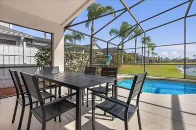 a dining room with a table and chairs and a pool at 3 Bedrooms 2 Bathrooms Lake Berkley home in Kissimmee