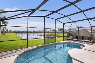 a view of a swimming pool with a pergola at 3 Bedrooms 2 Bathrooms Lake Berkley home in Kissimmee