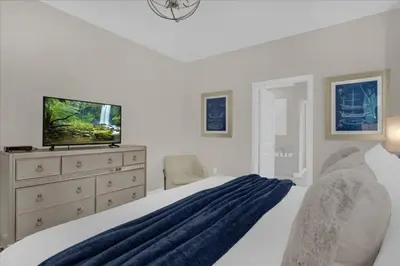 a bedroom with a bed with a tv and a dresser at 8 Bedroom & Theme Rooms For Kids In Storey Lake home in Kissimmee