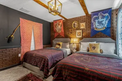 a bedroom with two beds in a room with a hogwarts at 8 Bedroom & Theme Rooms For Kids In Storey Lake home in Kissimmee