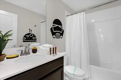 a bathroom with a sink and a toilet and a shower at 8 Bedroom & Theme Rooms For Kids In Storey Lake home in Kissimmee