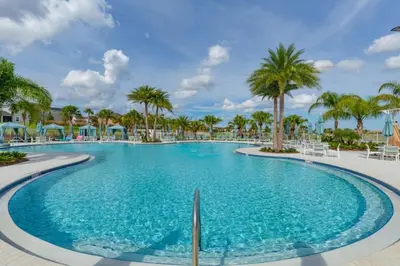 a swimming pool at a resort with palm trees at 5 Bedrooms 5,5 Bathrooms Solara home in Orlando