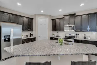 a kitchen with a granite counter top and stainless steel appliances at 5 Bedrooms 5,5 Bathrooms Solara home in Orlando