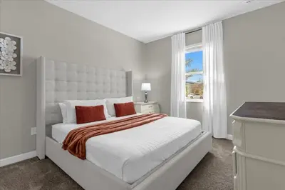 a white bedroom with a large bed and a window at 9 Bed Storey Lake Star Wars Dream Home home in Kissimmee