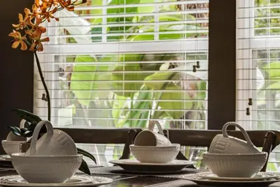 a table with plates and bowls on top of it at 4 Bedrooms 3 Bathrooms Lucaya Village townhouse in Kissimmee