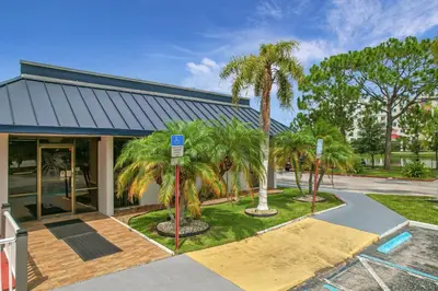 a building with palm trees in front of it at Stayable Kissimmee East in Kissimmee
