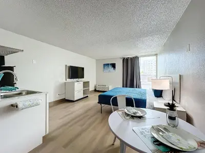 a hotel room with a bed and a table and a kitchen at Stayable Kissimmee East in Kissimmee