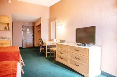 a hotel room with a television on a dresser at Stayable Kissimmee East in Kissimmee