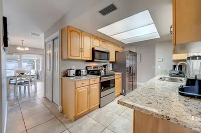 a kitchen with wooden cabinets and a counter top at Spacious Casselberry House with Backyard Pool in Orlando