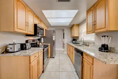 a large kitchen with wooden cabinets and appliances at Spacious Casselberry House with Backyard Pool in Orlando