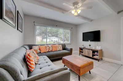 a living room with a couch and a flat screen tv at Spacious Casselberry House with Backyard Pool in Orlando