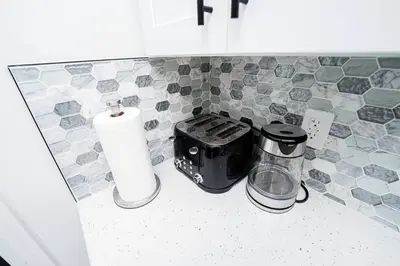 a kitchen counter with a toaster and a roll of paper towels at Close to the Action, Peaceful When You Return in Orlando
