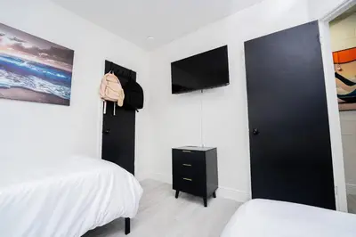 a bedroom with a black door and a bed and a tv at Close to the Action, Peaceful When You Return in Orlando