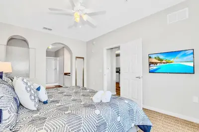 a white bedroom with a bed and a ceiling fan at Modern 3BR Resort Condo with Pool near Disney in Orlando