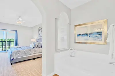 a white bedroom with a bed and a bath tub at Modern 3BR Resort Condo with Pool near Disney in Orlando