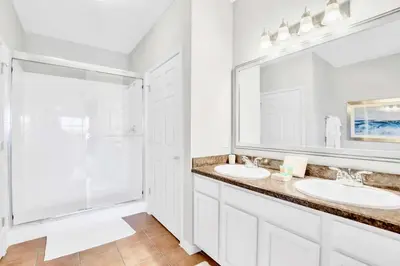 a white bathroom with two sinks and a shower at Modern 3BR Resort Condo with Pool near Disney in Orlando