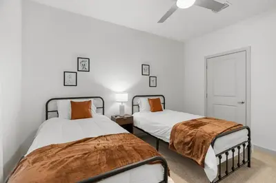 two beds in a bedroom with white walls at Magical Retreat Outside of Disney in Orlando