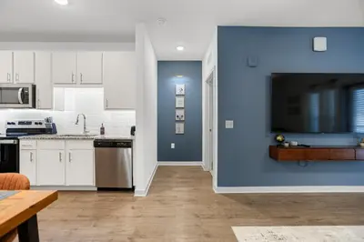 a kitchen with white cabinets and a blue wall at Magical Retreat Outside of Disney in Orlando