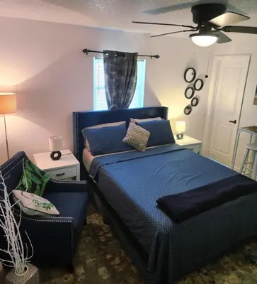 a bedroom with a blue bed and a chair at Private 1 Bedroom Suite Near Orlando Attractions in Orlando