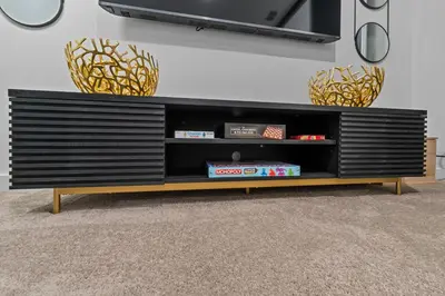 a black entertainment center with a tv on a wall at Bright Modern Townhome Retreat in Kissimmee
