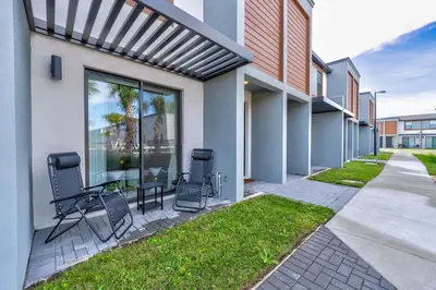 a patio with chairs and a table in front of a building at Bright Modern Townhome Retreat in Kissimmee