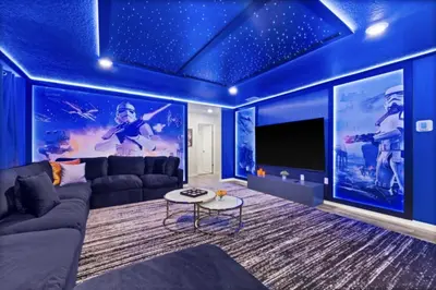 a blue living room with a couch and a tv at New 2025 Bambi Orlando Pool Vacation Home in Clermont