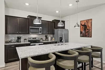 a kitchen with a counter with bar stools at New 2025 Bambi Orlando Pool Vacation Home in Clermont