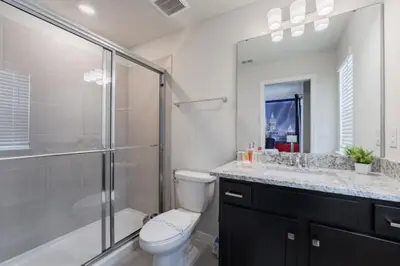 a bathroom with a shower and a toilet and a sink at New 2025 Bambi Orlando Pool Vacation Home in Clermont