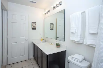 a bathroom with a sink and a mirror and a toilet at Family Friendly 4 Bedrooms with GameRoom close to Disney in Compass Bay 5103 in Kissimmee