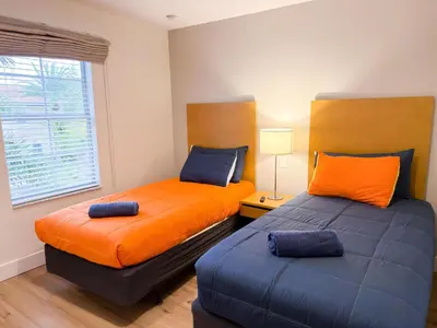two beds in a room with orange and blue at ER3047WOR - Cozy 3BD Townhome w/ Private Hot Tub in Kissimmee