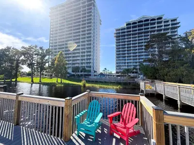 three chairs sitting on a deck next to a river at BHBR207 - Condo Close to Disney - 1 mile in Orlando