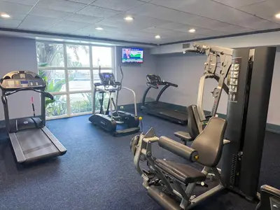 a gym with several tread machines in a room at BHBR207 - Condo Close to Disney - 1 mile in Orlando