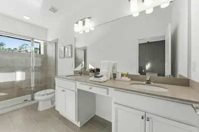 a bathroom with two sinks and a toilet and a mirror at Paradiso Grande 5Q c Piscina e Quartos Temáticos in Orlando
