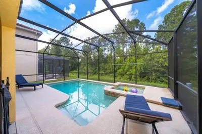 a swimming pool in a house with a glass house at Florida Dreaming home in Kissimmee