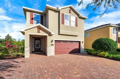a large house with a brick driveway at Home With Private Pool, Theme & Game Room Near Disney With Resort & Waterpark Access - 7521Mr in Orlando