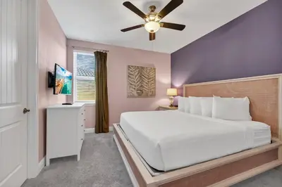 a bedroom with a white bed and a ceiling fan at Home With Private Pool, Theme & Game Room Near Disney With Resort & Waterpark Access - 7521Mr in Orlando