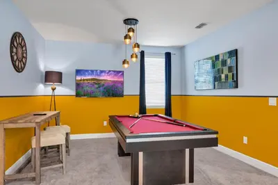 a pool table in a room with yellow walls at Home With Private Pool, Theme & Game Room Near Disney With Resort & Waterpark Access - 7521Mr in Orlando