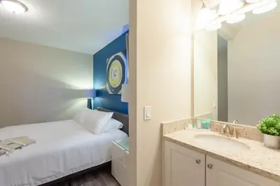 a bedroom with a bed and a sink and a mirror at Incredible 8BR PetFriendly Encore Resort next to Disney - 7474 in Orlando