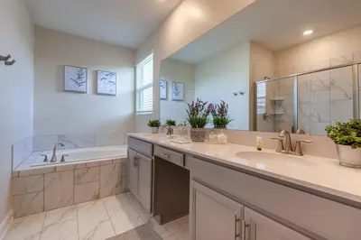 a bathroom with two sinks and a bath tub and a tubermott at Amazing 6BR at Storey Lake next to Disney - 2835 in Kissimmee