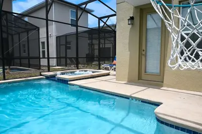a swimming pool in front of a building with a basketball hoop at Gorgeous 5BR at Storey Lake next to Disney - 2924 in Kissimmee
