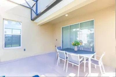 a dining room with a blue table and chairs at Gorgeous 5BR at Storey Lake next to Disney - 2924 in Kissimmee