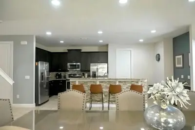 a kitchen with a table with chairs and a counter top at Gorgeous 8BR PetFriendly at Encore Resort next to Disney - 7625 in Orlando