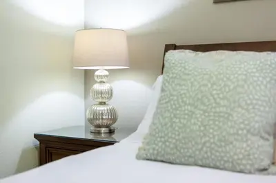 a bedroom with a bed with a lamp and a pillow at Gorgeous 8BR PetFriendly at Encore Resort next to Disney - 7625 in Orlando