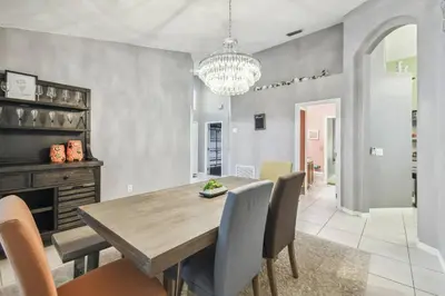 a dining room with a wooden table and chairs at Lake Berkley 5Q, Piscina Aquecida, Perto Disney in Kissimmee