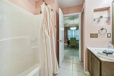 a bathroom with a shower and a tub and a sink at Lake Berkley 5Q, Piscina Aquecida, Perto Disney in Kissimmee