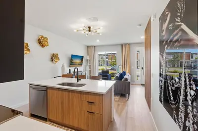 a kitchen with a sink and a living room at The Hub Beautiful Townhome Near Parks in Kissimmee