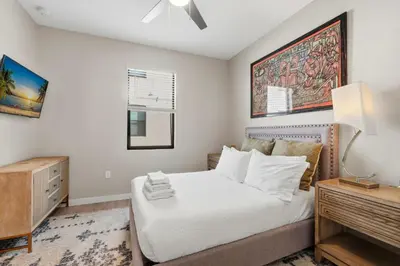 a bedroom with a bed and a desk with a lamp at The Hub Beautiful Townhome Near Parks in Kissimmee