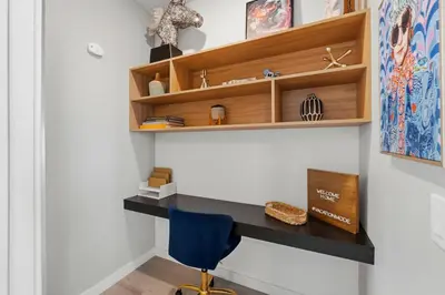 a desk in a room with a blue chair at The Hub Beautiful Townhome Near Parks in Kissimmee