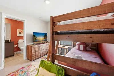 a bedroom with two bunk beds and a bathroom at The Hub Beautiful Townhome Near Parks in Kissimmee